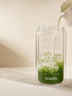 將牛奶倒入裝有凍抹茶嘅 Teasis 儀式杯，杯身刻度清晰可見