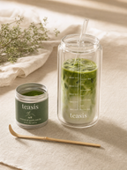 Teasis 儀式杯盛載凍抹茶拿鐵，旁邊有開咗嘅 Teasis 抹茶罐同竹茶杝，喙柔和晨光下